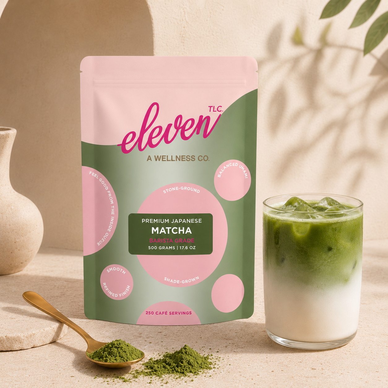 Eleven TLC Organic Japanese Barista Matcha Powder 500g, displayed with a prepared matcha latte in a glass and a wooden spoon of matcha powder on a neutral surface