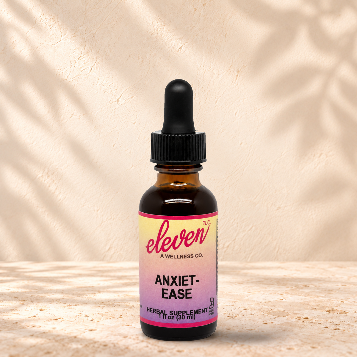 Eleven TLC Anxiet-Ease herbal tincture for calm and clarity, 1 fl oz amber dropper bottle with pink and yellow label
