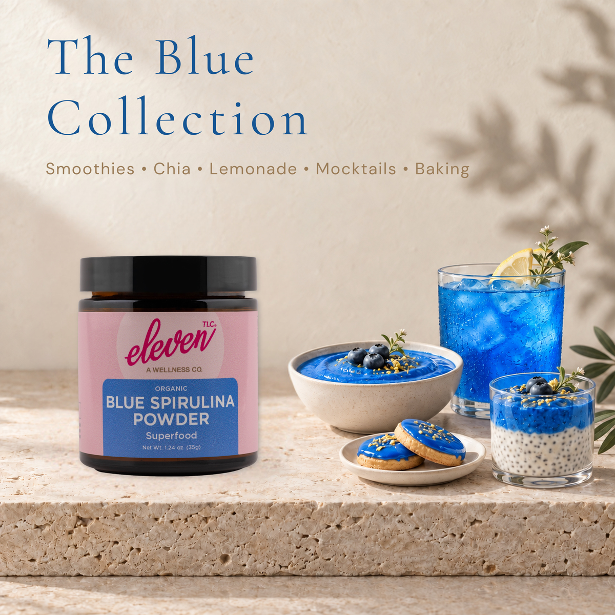 Eleven TLC blue spirulina powder beside a blue smoothie bowl, chia pudding, iced drink and blue-frosted cookies.