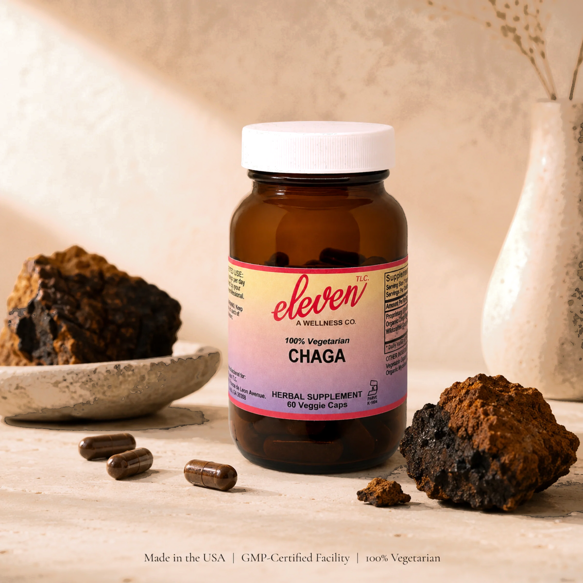 Eleven TLC 60-count Organic Chaga Mushroom capsules bottle displayed on wood surface with wildcrafted chaga mushrooms.