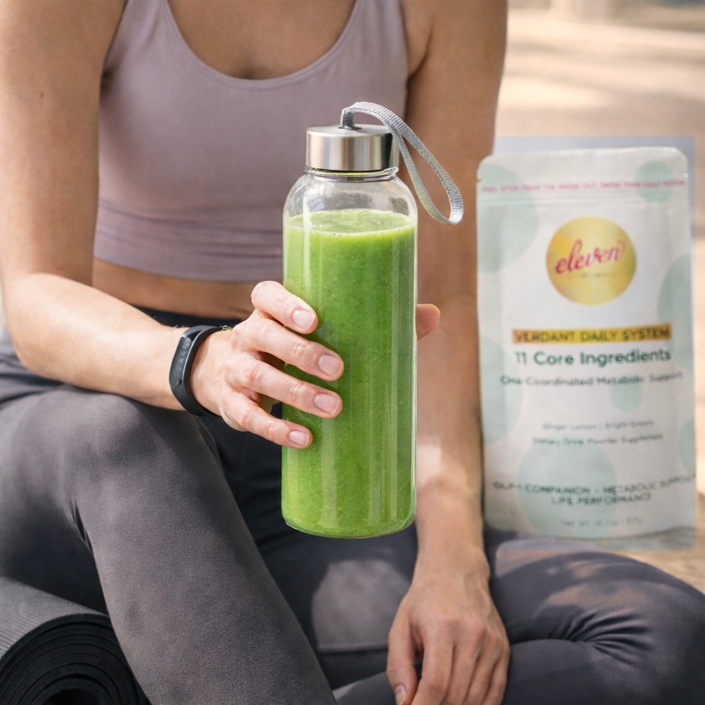 Person holding a glass bottle of green Verdant Daily System drink beside the Eleven TLC 517g pouch.