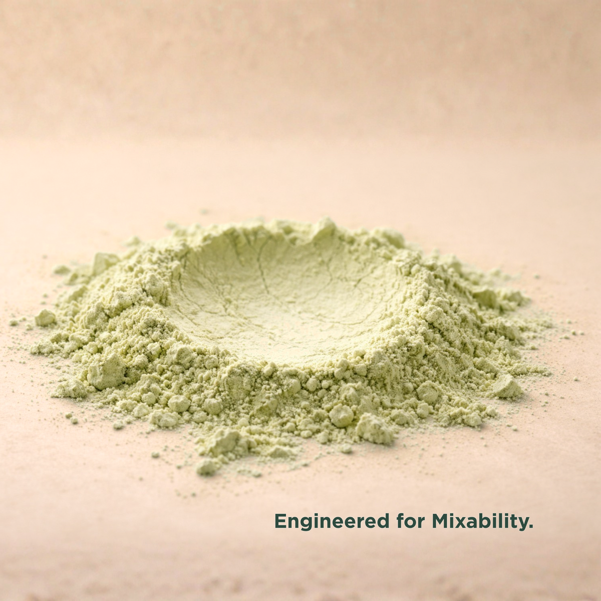 Close-up of fine-milled Verdant Daily System green powder on a warm cream surface, showing its smooth, mixable texture.