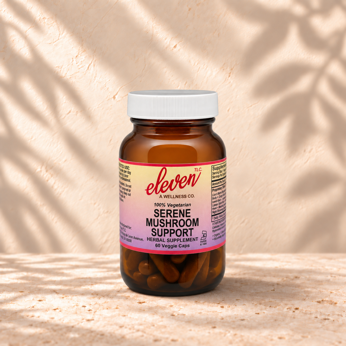 Eleven TLC Serene Mushroom Support herbal supplement, 60 veggie capsules in an amber glass bottle on a stone surface with soft leaf shadows