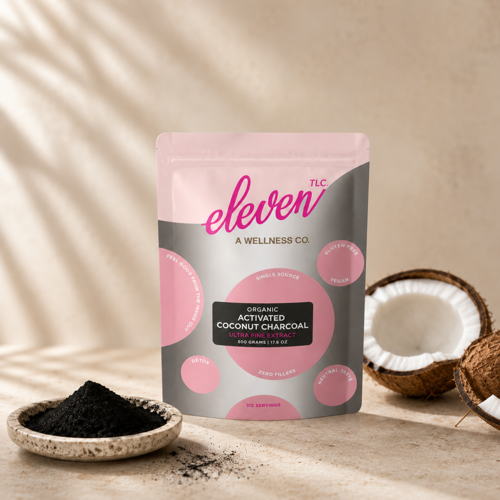 Eleven TLC Organic Activated Coconut Charcoal Powder in 500g resealable pouch next to a bowl of charcoal and a coconut.