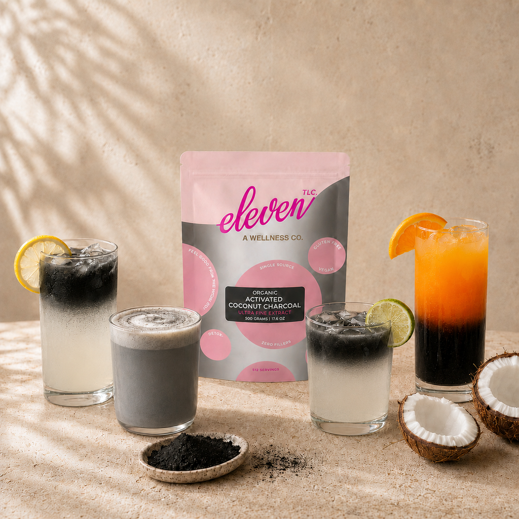 Eleven TLC Activated Coconut Charcoal Powder 500g pouch centered among three detox-infused charcoal beverages and fresh coconut halves on a warm, minimalist surface.