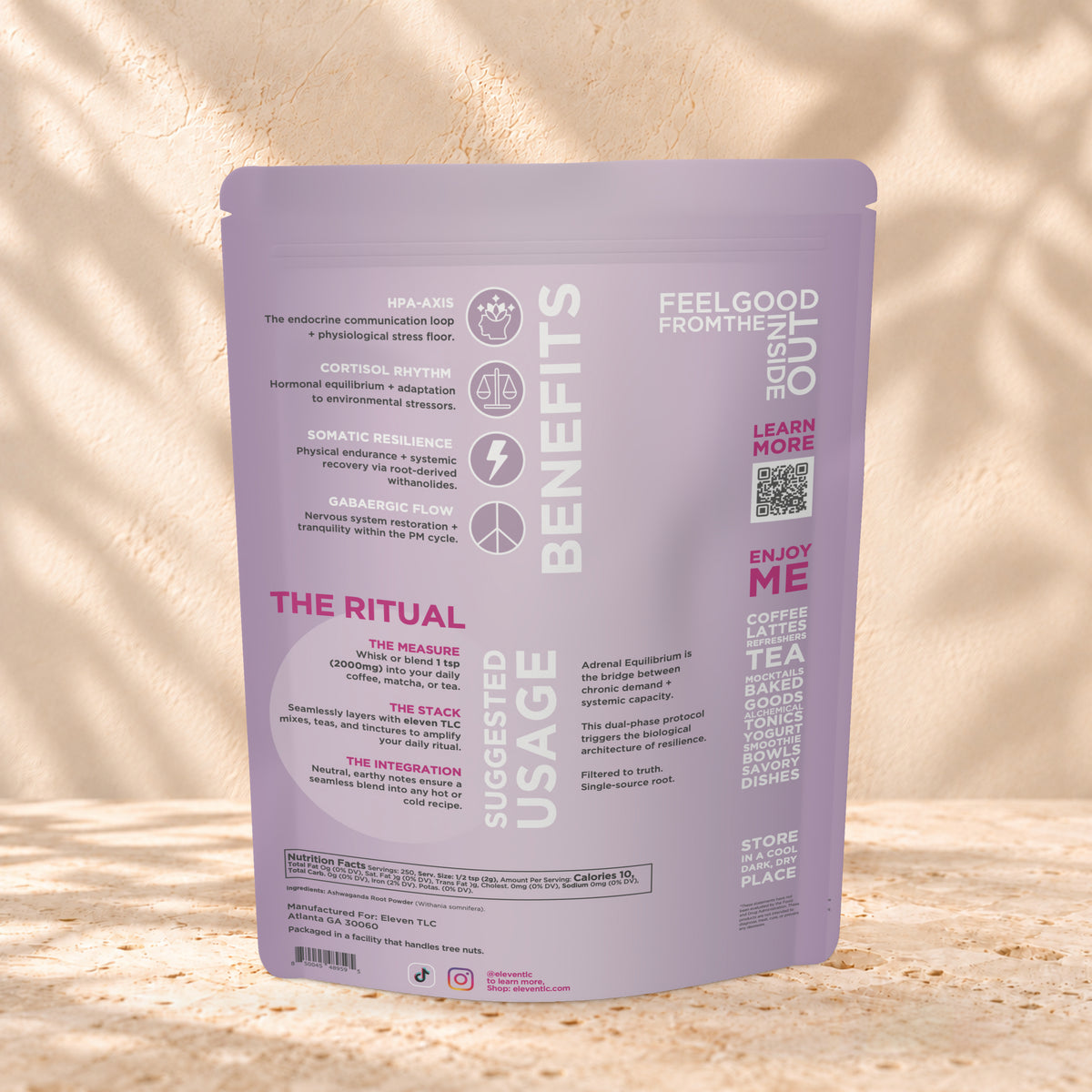 Back view of an Eleven TLC Ashwagandha Powder 500g pouch on warm travertine against a cream plaster wall with botanical shadows.