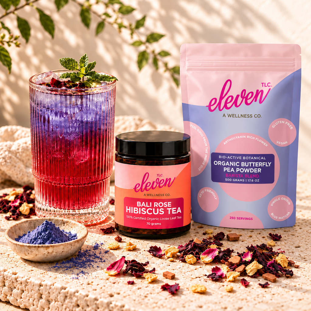 Bali Bloom hibiscus iced tea with violet butterfly pea ice beside an Eleven TLC Bali Rose tea jar and Organic Butterfly Pea Powder 500g pouch on sunlit travertine.