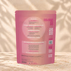 Back view of an Eleven TLC Bali Rose Tea 360g pouch on warm travertine against a cream plaster wall with botanical shadows.