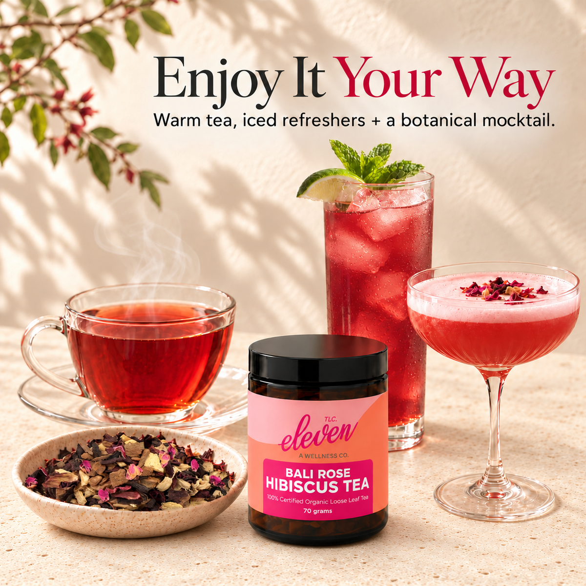 Eleven TLC Bali Rose Hibiscus Tea served hot, iced with mint and lime, and as a botanical mocktail, beside a 70g jar and bowl of loose-leaf tea on cream travertine.