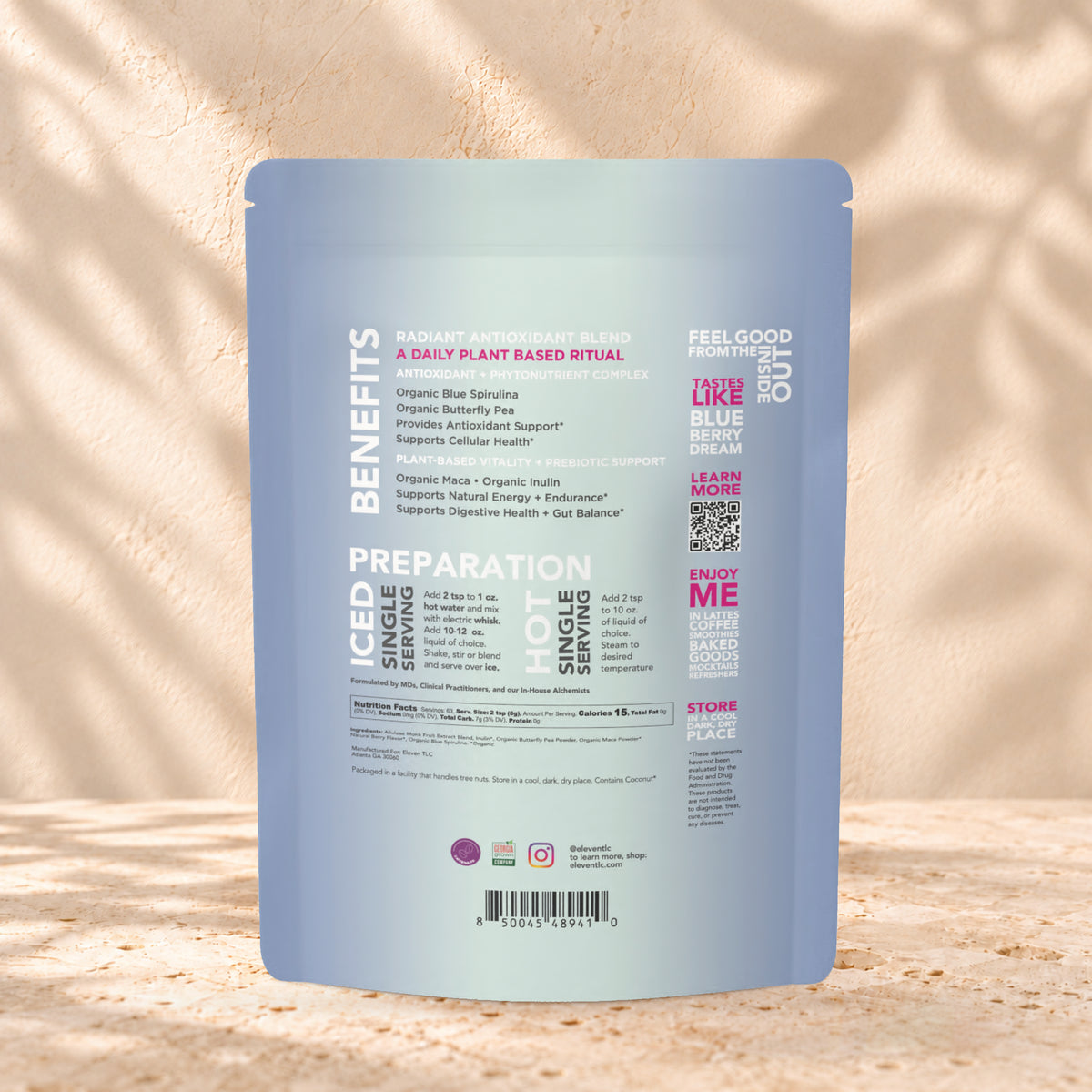 Back view of an Eleven TLC Berry Well 500g pouch on warm travertine against a cream plaster wall with botanical shadows.