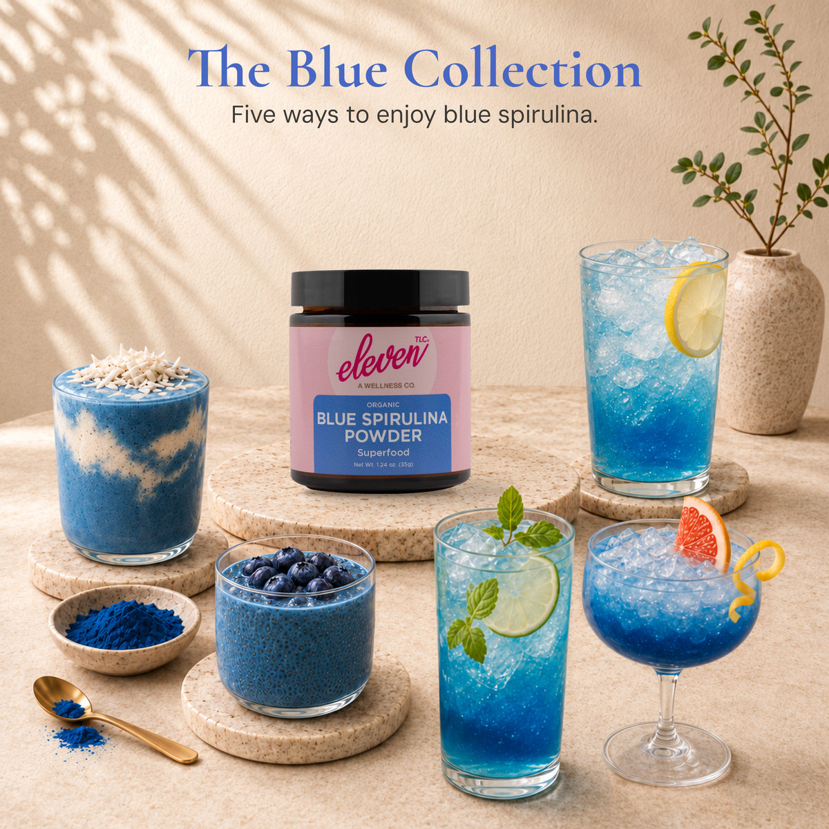 Eleven TLC blue spirulina jar surrounded by five blue food and drink preparations on warm stone.