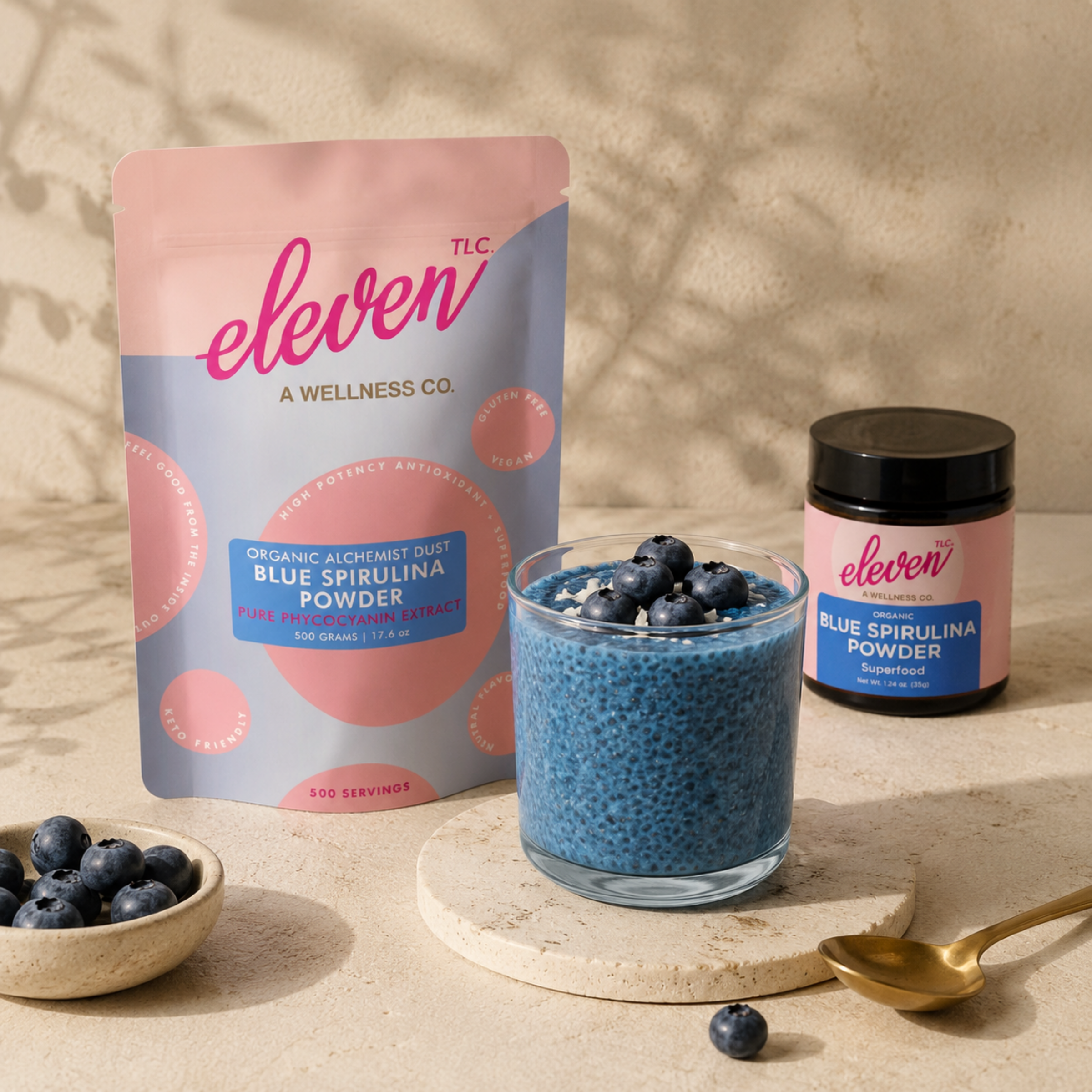 Eleven TLC 500g bulk pouch and retail jar of organic Blue Spirulina powder with chia pudding on marble surface.