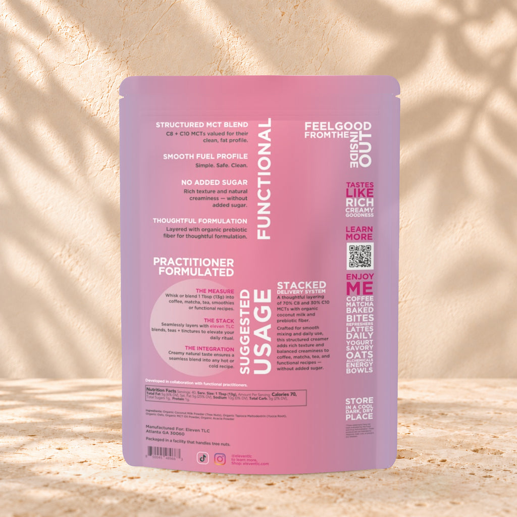Back view of an Eleven TLC Coconut MCT Oat Creamer 500g pouch on warm travertine against a cream plaster wall with botanical shadows.
