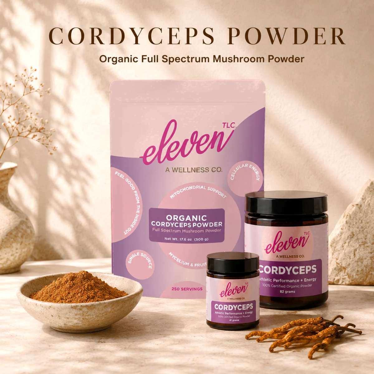 Eleven TLC Organic Cordyceps Mushroom Powder in 41g and 82g amber glass jars and the 500g pouch, with a bowl of powder and whole cordyceps mushrooms on a warm cream background.