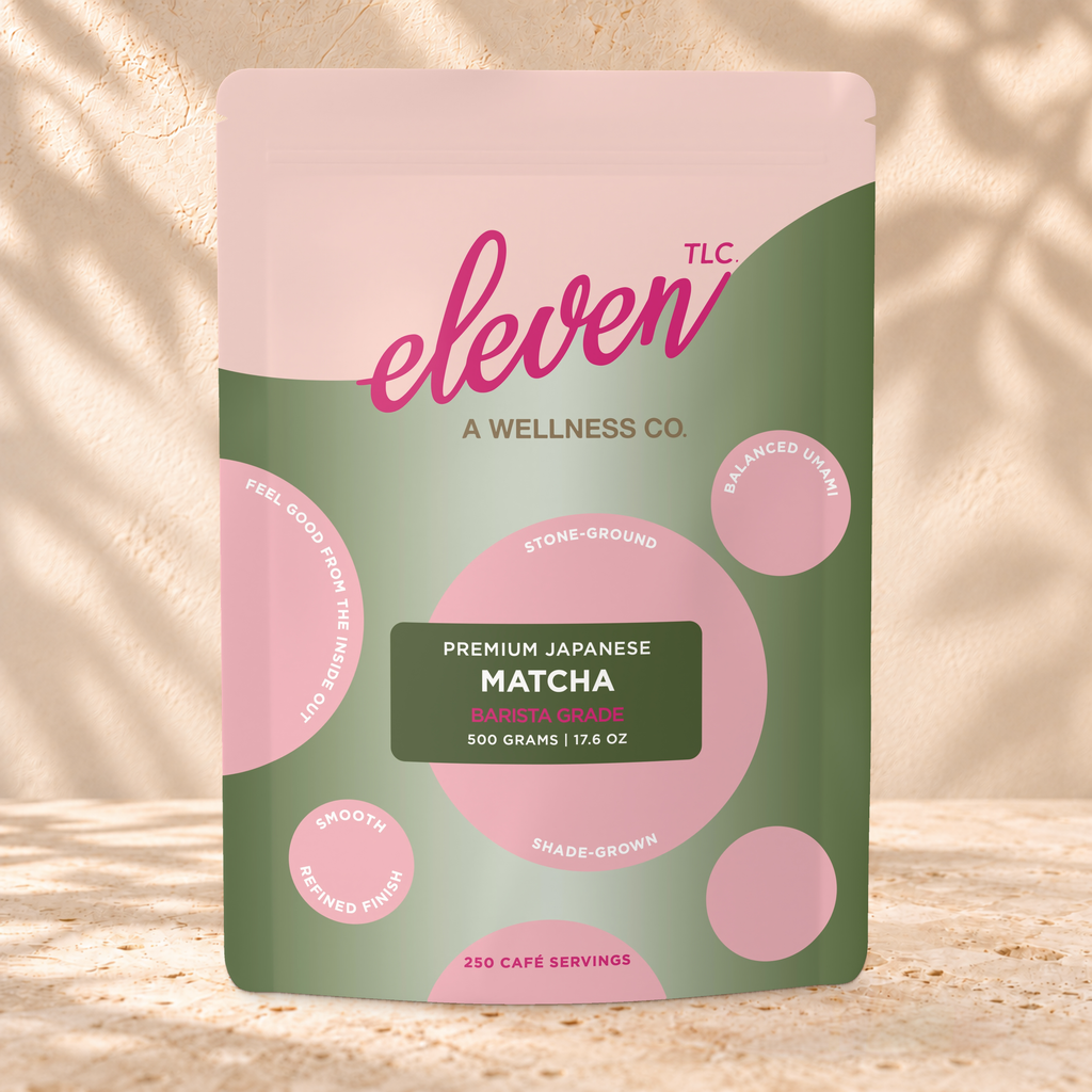 Front view of an Eleven TLC Japanese Matcha 500g pouch on warm travertine against a cream plaster wall with botanical shadows.