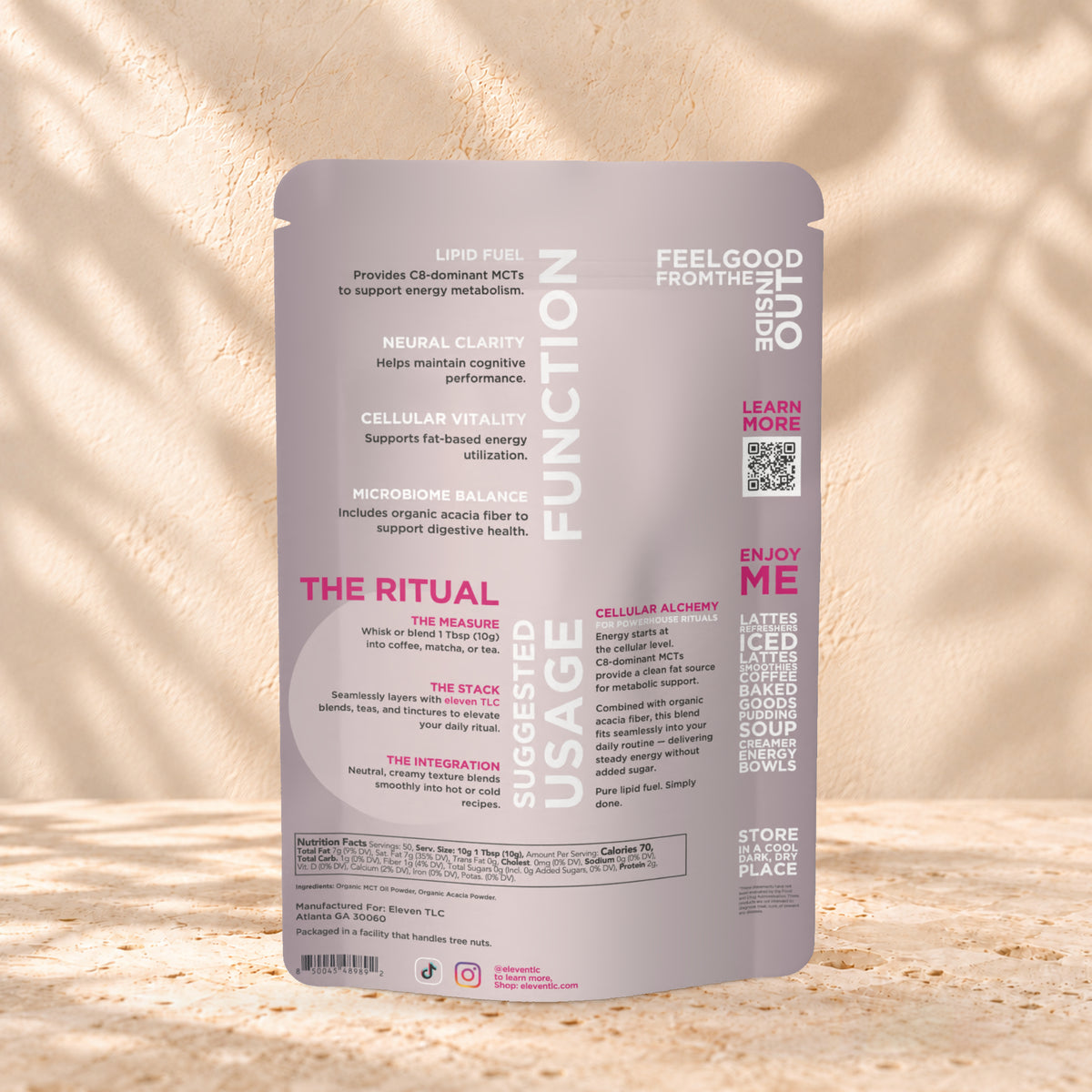 Back view of an Eleven TLC MCT Oil Powder 500g pouch on warm travertine against a cream plaster wall with botanical shadows.