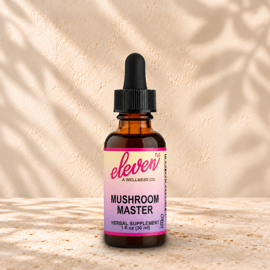 Eleven TLC Mushroom Master 1 fl oz tincture in an amber glass bottle with a black dropper on warm travertine against a cream plaster wall.