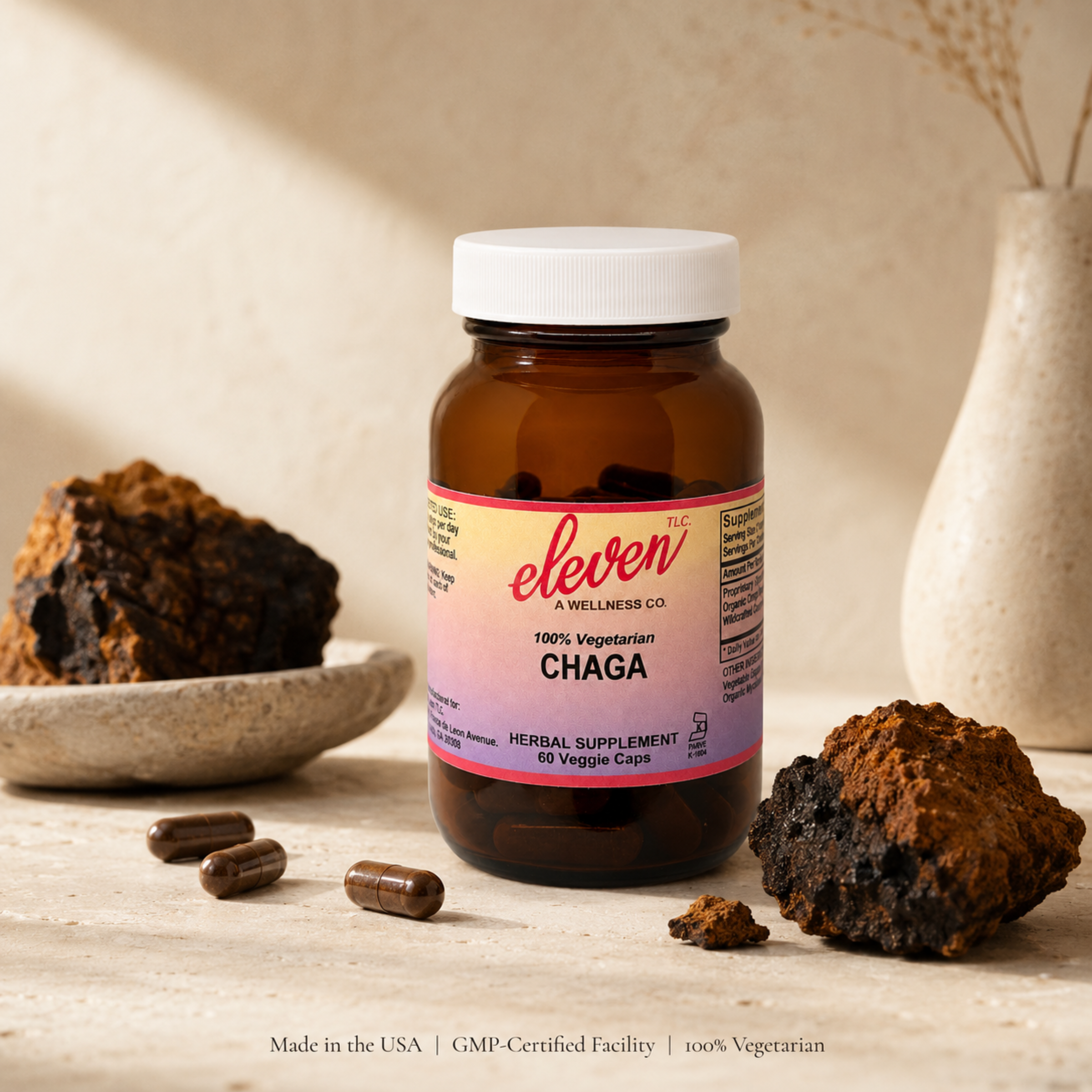 Eleven TLC 60-count Organic Chaga Mushroom capsules bottle displayed on wood surface with wildcrafted chaga mushrooms.