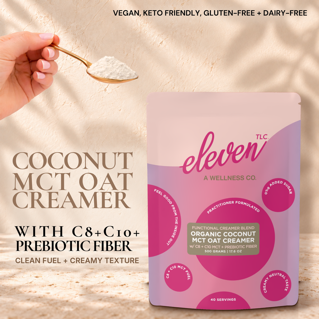 Eleven TLC Organic Coconut MCT Oat Creamer 500g pouch on travertine against a warm cream plaster wall, with a hand holding a gold spoon of creamer powder. Text reads Coconut MCT Oat Creamer with C8 + C10 + prebiotic fiber, clean fuel + creamy texture; vegan, keto friendly, gluten-free + dairy-free.