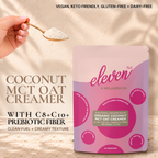 Eleven TLC Organic Coconut MCT Oat Creamer 500g pouch on travertine against a warm cream plaster wall, with a hand holding a gold spoon of creamer powder. Text reads Coconut MCT Oat Creamer with C8 + C10 + prebiotic fiber, clean fuel + creamy texture; vegan, keto friendly, gluten-free + dairy-free.