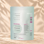 Back view of an Eleven TLC Reishi Mushroom Powder 500g pouch on warm travertine against a cream plaster wall with botanical shadows.