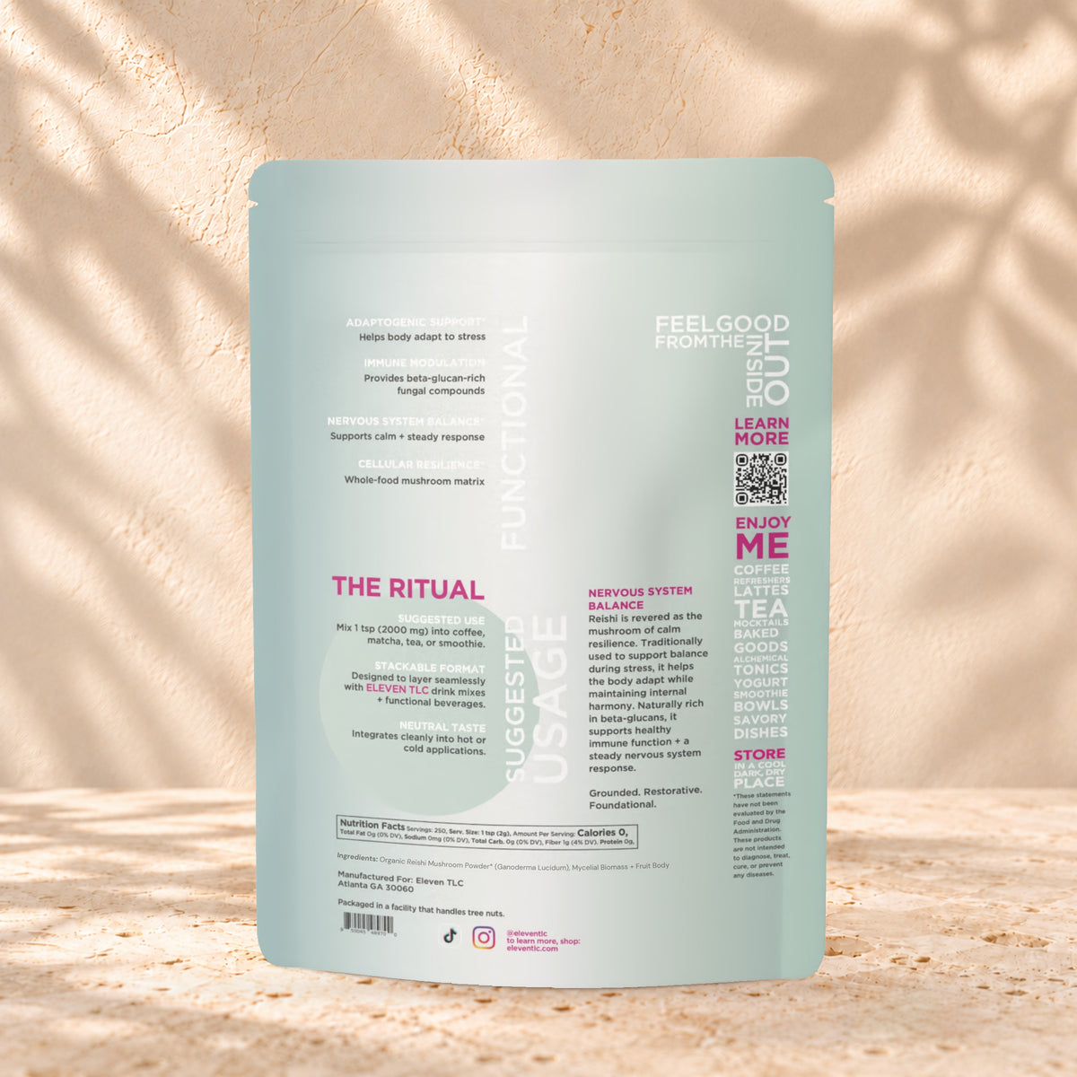 Back view of an Eleven TLC Reishi Mushroom Powder 500g pouch on warm travertine against a cream plaster wall with botanical shadows.